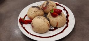 Kynuté knedlíky plněné jahodami, sypané mákem, přelité datlovým sirupem at Jídelna U tří Vegetariánů in Usti Nad Orlici