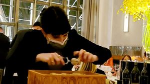 Grating ginger into powder to top smoked white asparagus at Eleven Madison Park in New York City