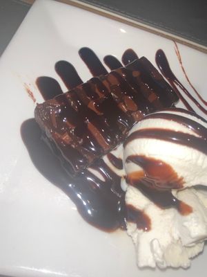 Vegan chocolate brownie with vegan vanilla ice cream and chocolate sauce.  at The White Swan Inn in Lowick