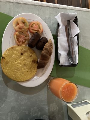 Desayuno- arepa, tomatoes, sausages, sweet bread and juice for 6000 COP  at El Enebro in Pereira