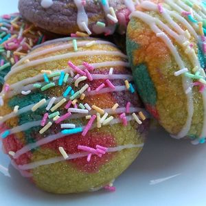 Unicorn poos: Slightly fruity, always fluffy and absolutely delicious.  A caramel flavour glaze, sprinkles and edible glitter add a bit of magic to the mix. at Angel's Sinfully Delicious Cookie Company in Long Eaton