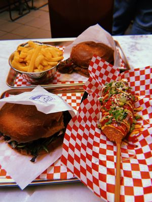 Double smash bacon burger, kitsune tofu burger with fries and a corn dog at Kitsune Burgers in Brussels