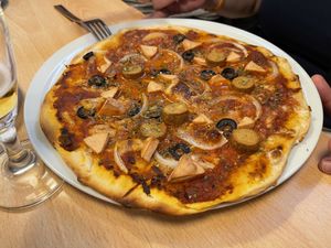 PIZZA ROMANA 
Pizza de masa casera con base de tomate frito, mozzarela, cebolla, rodajas de oliva negra, lonchas de Frankfurt, dados de mortadela y orégano. at A Flama in Zaragoza