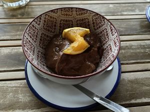 A “nata” dessert that has cacao and oatmeal and porto wine and topped with oranges. It is not a sweet dessert. Very nice texture.  at La Hormiga in Pontevedra