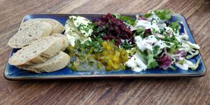Seasonal starter: Roasted bread with Cafe de Paris dip and cucumber relish. (June 2023) at Pfannenzauber in Aachen