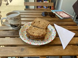 Seed risole sandwich and coffee with oat milk at Sebastien's Foods  in Paignton