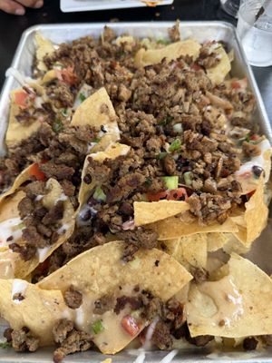 Loaded nachos with a mix of imposible meat & smoked shrooms. 7/10 for me. They can use some work. The smoked shrooms gives it more flavor.   at Mo' Brunch + Brews in Houston