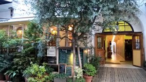 Street frontage covered in foliage. Outdoor seating/ smokers area behind.   at Modernark in Kobe