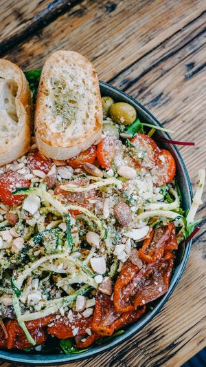 The fresh Elli Spirelli Bowl - Spirelli-zucchini, panned in almond-arugula-pesto, olives, dried tomatoes, wild salad and roasted rosemary bread. at Froindlichst in Berlin