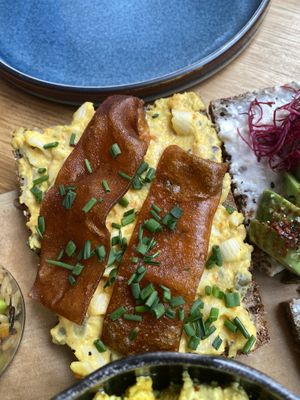 A slice of multigrain seed bread with egg salad, bacon and chives  at Froindlichst in Berlin