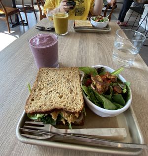 Goddess of beauty smoothie (purple) goddess of magic smoothie (tumeric), vegetarian mushroom melt (back sandwich), vegan smashed chickpea sandwich (front sandwich) at Khepri Cafe in Chicago