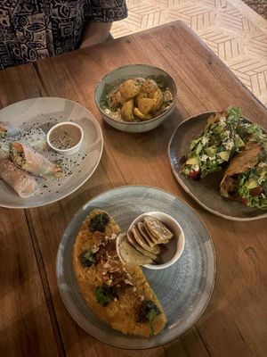 All vegan. Tofu summer rolls and peanut sauce. Crispy potatoes with a coconut cream cucumber sauce. Crispy tacos and risotto with these little bread dippers. at Gracias Vida in La Guajira