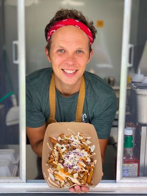 Owner Ryan Strandjord with Bacun Slaw Loaded Fries. at Plantology in Gainesville