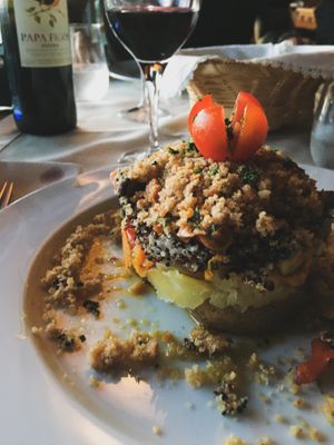 100% vegan dish with several layers of roasted potato on the bottom, sauté vegetables, sauté shiitake mushrooms with bell pepper, quinoa and toasted corn bread on top. at O Abocanhado in Braga