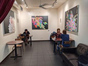 Indoor seating with multiple tables and a small couch. Local art on the walls for sale. at Kilovolt Coffee in Oakland
