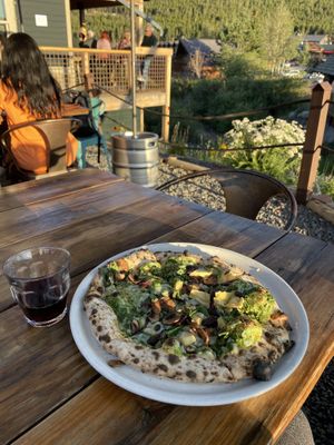 Pesto pizza with vegan cheese and glass of wine.   at Crosscut Pizzeria and Taphouse in Nederland