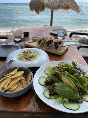 Full spread: green avocado salad, vegan mushroom ceviche, Campeche vegan tacos and dos margaritas  at La Lunita in Akumal