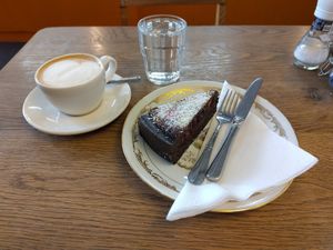 Small cappuccino with oatmilk and vegan fruit-berries-chocolate cake. at De Bakkerswinkel - Kahvalti in Amsterdam