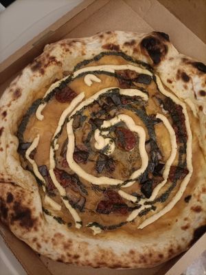 Pizza Cecina con salsa di pomodoro giallo, melanzane fritte, pomodorini secchi, Hummus e olio al basilico at PanePizza in Padua