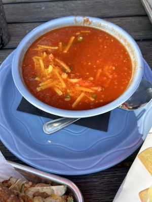 Bowl of tomato soup topped with vegan cheese  at All Souls Lounge in Salem