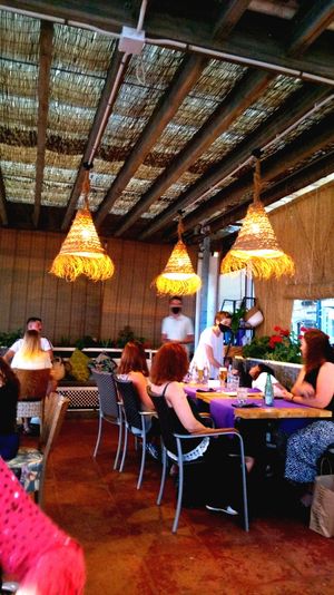 Outside seating area under a beach roof at Gusto BistroBar in Blanes