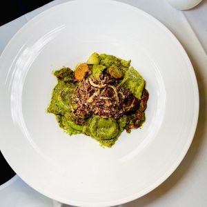 Fava Bean Ravioli. Pea shoot pesto, fava filling, sun-dried tomatoes, rainbow carrots, crispy leeks, spinach-infused pasta  at True Bistro in Somerville