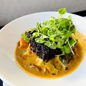 Thai Red Curry and Rice Cake. forbidden black rice, coconut curry, local fried tofu, sugar snap peas, sesame roasted oyster mushrooms, Thai basil  at True Bistro in Somerville
