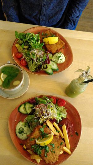 Top: vegan schnitzel with potato salad and greens, right: smoothie, bottom: schnitzel with fries and side salad, left: fresh lemon-ginger team with mint leaves. at Max Pett in Munich