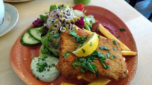 Vegan schnitzel with side salad, vegan herb sauce and topped with parsley and fresh lemon. at Max Pett in Munich