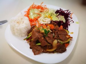 faux beef dish with side order of rice and salad at Loving Hut - Nowolipie in Warsaw