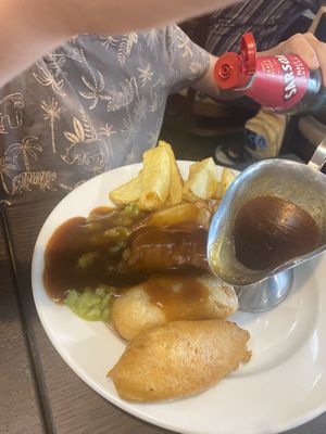 Battered sausage, chips, mushy peas and gravyy  at The Queen Inn in Cwmbran