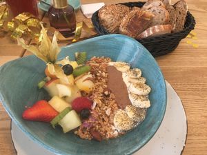 Lula-Frühstücksbowl: Soja-Joghurt, Mandelmus, Obst, hausgemachtes Granola und Brotkorb, der mit dem veganen oder vegetarischen Frühstück gebracht wird   at Lula in Berlin