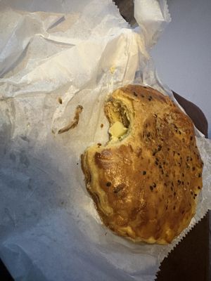 Potato empanada labelled as “vegan” but with chicken bone and meat in it.  at Café Monteverde Coffee Shop in Monteverde