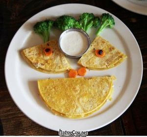 Corn tortillas layered with melted cheeses with carrot and broccoli garnish at Native Foods in Culver City