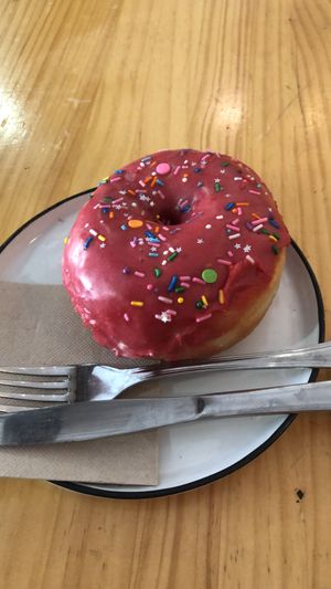 Los donuts son un espectáculo. Este de frambuesa fue todo un acierto y su marcha latte muy rico también.   at Delish Vegan Doughnuts - Malasaña in Madrid