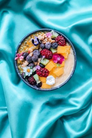 Let The Man Go - Mango, passion, pineapple, banana base! With seasonal fruits, our house-made chai-spice granola and edible micro-flowers  at Kappra Cafe in Bangkok