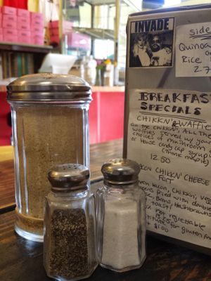 From the community table facing the counter...  napkin holder with menu selection in the foreground, counter and donut case in the background at Pepples Donut Farm in Berkeley