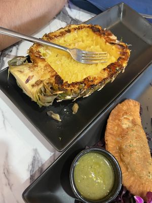 The pineapple that was left after my husband ate the pineapple fried rice. Also, one of the empanadas is in the photo.  at Gaia & Loki in Jersey City