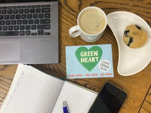 Flat lay of Green Heart Collective cafe seating area with coffee and vegan blueberry muffin at Green Heart Collective in Gateshead