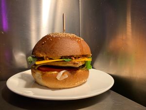 Tofu Burger - fried tofu, eggplant, marinated onion and cucumber, fresh tomato and salad, crunchy onion, black sesam, vegan Cheddar and curry-mustard sauce at El Forat in Barcelona