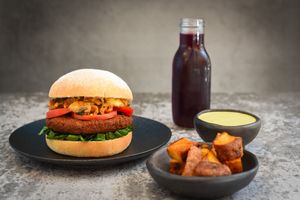 Hamburguesa Ventimiglia (Falafel, champiñones al ajo, salsa napolitana con albahaca y tomates, espinaca, en pan artesanal). Combo con papas en casco y agua de flor de jamaica.  at La Lleva in Bogota