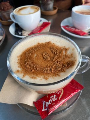 Chai Latte with oat milk. Dark chocolate and peanut butter crunch in the background.  at Delikat  in Viersen