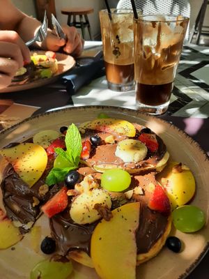 Chocolate pancakes with seasonal fruits & almond milk frappes at Libre Garden in Pefkochori