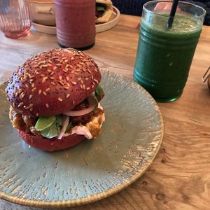 Cauliflower katsu burger on beetroot bread (sweeter than normal bread) with a super green smoothie.  Also a mixed berry smoothie in the background. at Out-there Artisan in Jedburgh