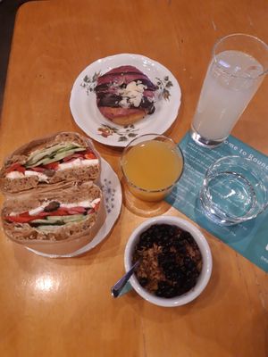 Brunch with olive feta bagel, lemonade and blueberry-chocolate donut, juice and granola bowl. at ROUND - Helsinginkatu in Helsinki