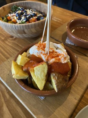 Patatas Bravas (Ve), Kale Salad (Ve). Also had the pedron peppers (Ve), Tomate de Pan (Ve), and bread with hummus and carrots (Ve)   at Bubar in Barcelona