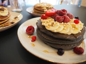 Home made vegan and gluten free pancakes with charcoal, red fruits, quinoa, banana, maple syrup at Peacock in Toulouse