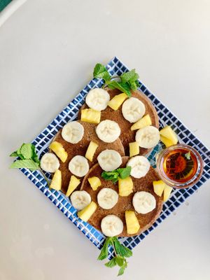 Whole foods banana pancakes with pineapple, sliced banana, mint and maple syrup 😍 at REVIV in Malaga
