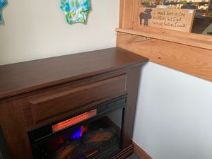 Ceramic fireplace with a wooden moose tchotchke that says, “I wasn’t born in the mountains, but I got here as fast as I could.” at Fired On The Mountain Cafe in Lincoln