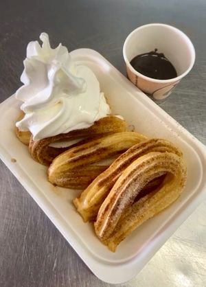 Churros with a dusting of cinnamon and sugar with Whippy and dipping chocolate sauce. Delicious! at Ice Cafe in Brighton